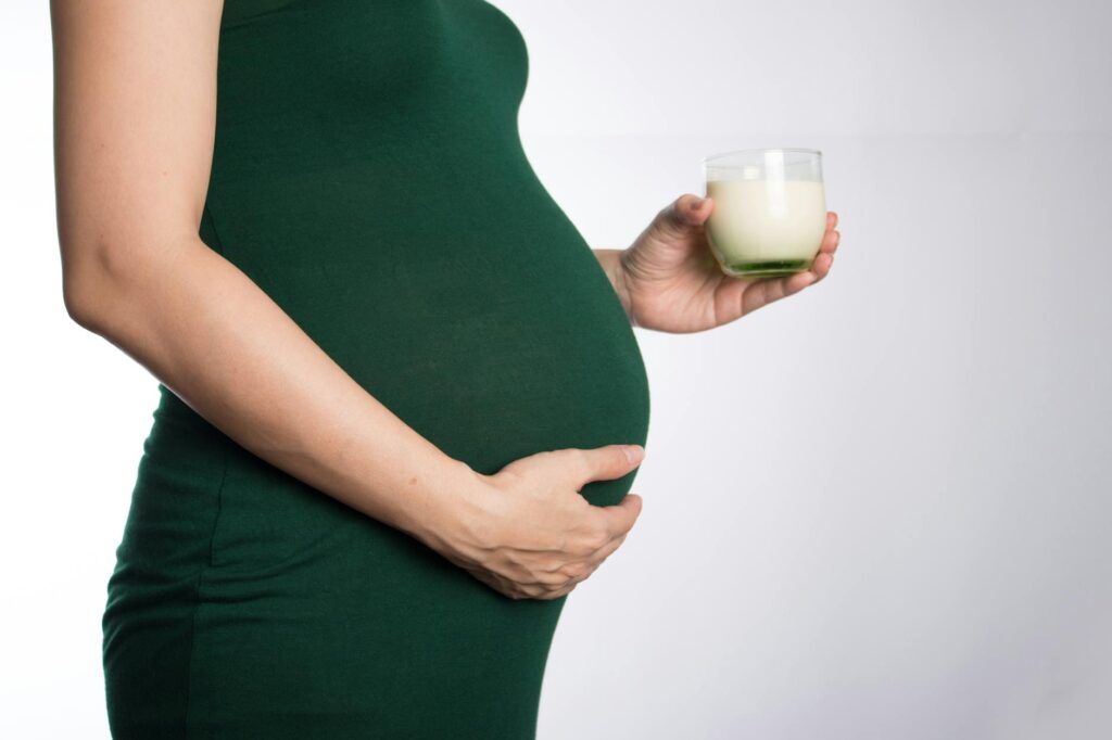 pregnant woman holding a glass of milk