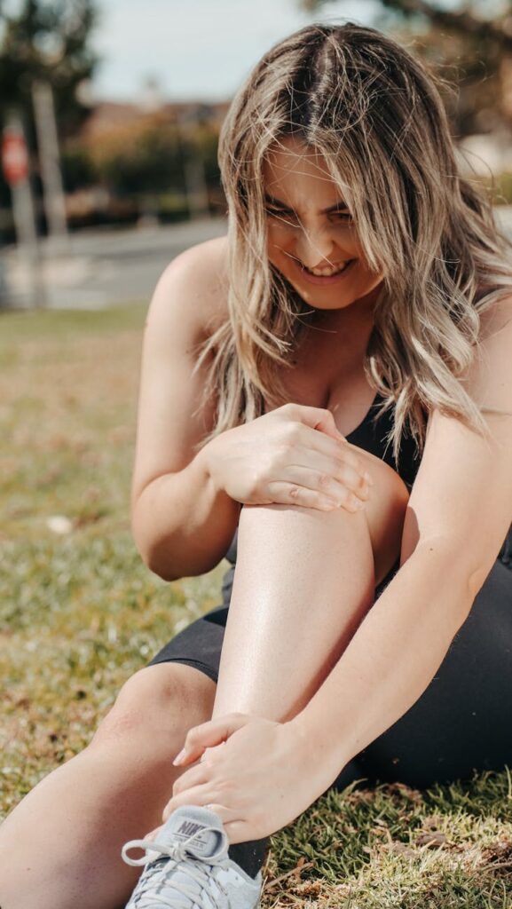a woman in black tank top sitting on green grass