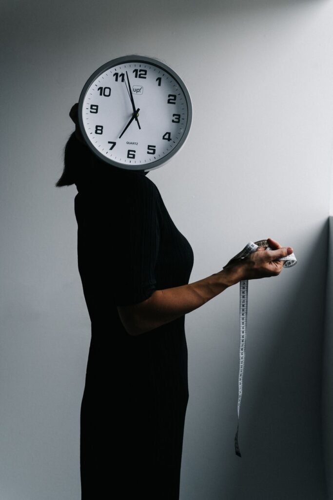 woman with clock instead of head and measuring tape